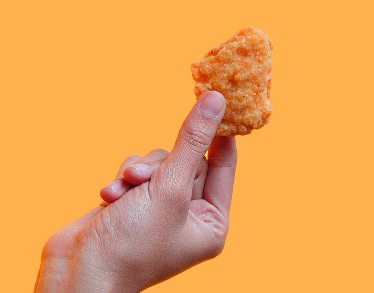 hand vasthouden kip nugget - kunnen katten kipnuggets eten?