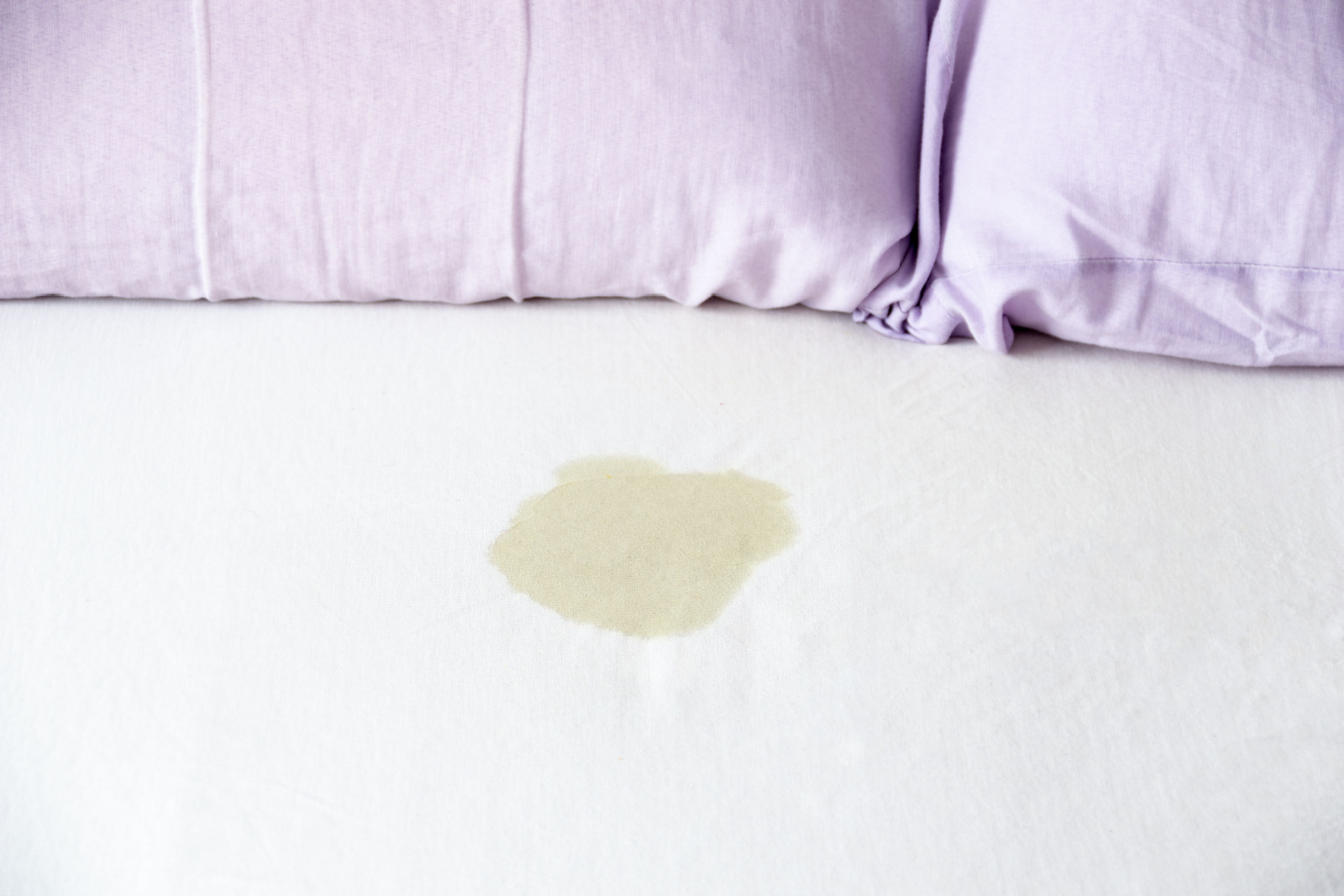 sluit urineresten op een bed veroorzaakt door een huisdier op het bed in de slaapkamer