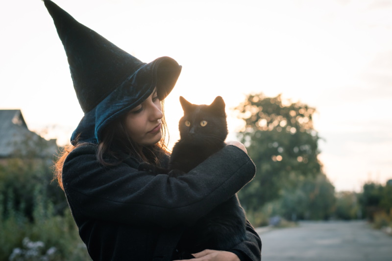 vrouw in hallowen kostuum het vasthouden van kat