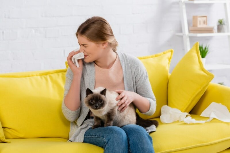 vrouw met allergie die kat vasthoudt