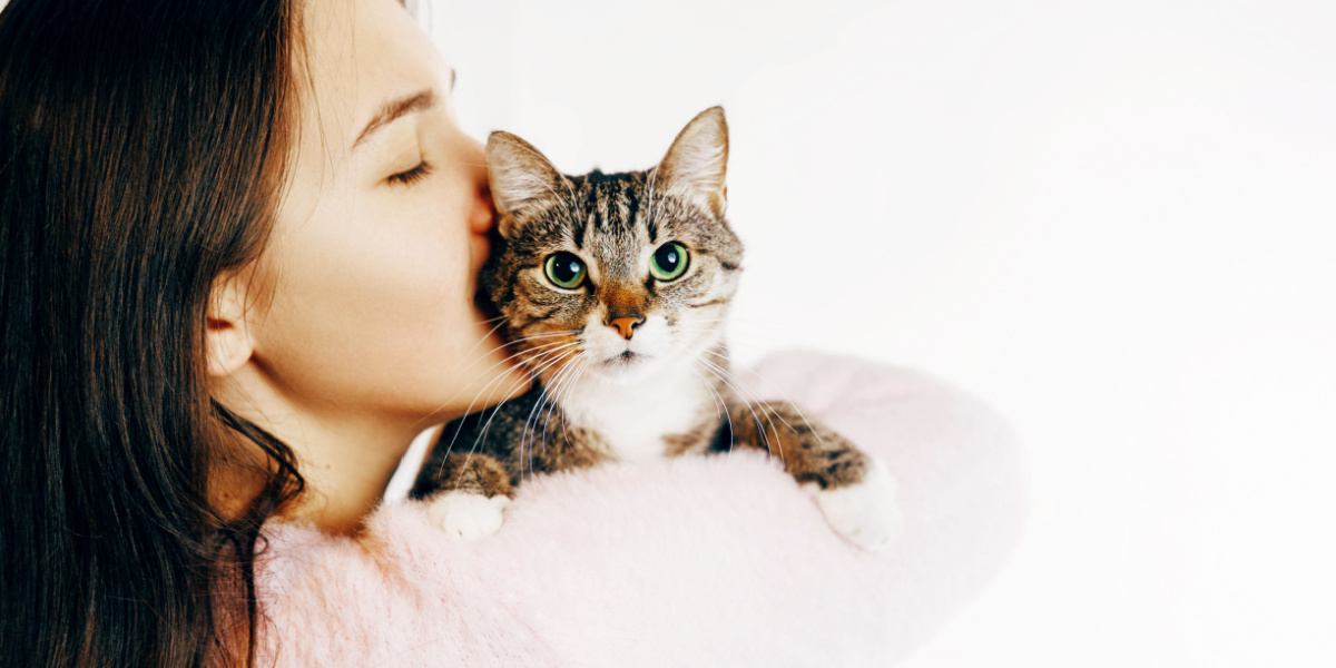 vrouw kusjes en knuffels kat