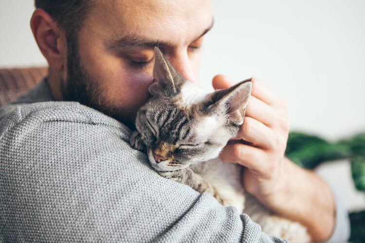 man knuffelende kat