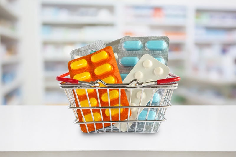 medicijnpillen pakket in winkelmandje met apotheek wazige achtergrond